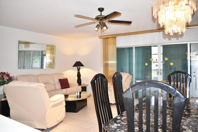 dining room featuring light tile patterned floors, ceiling fan with notable chandelier, and a textured ceiling