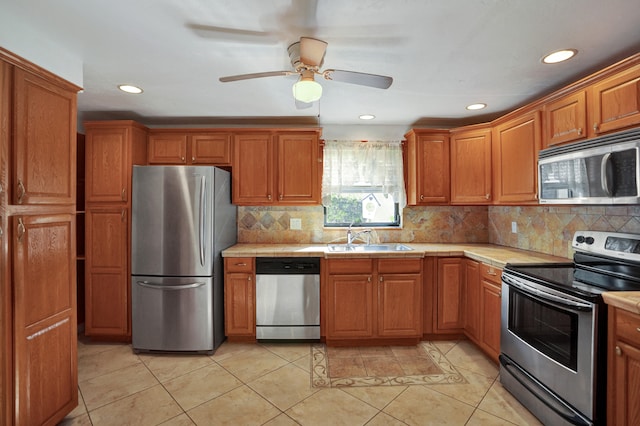 kitchen featuring ceiling fan, sink, light tile patterned flooring, and stainless steel appliances