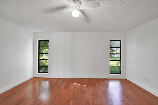 empty room with ceiling fan, a textured ceiling, and hardwood / wood-style flooring