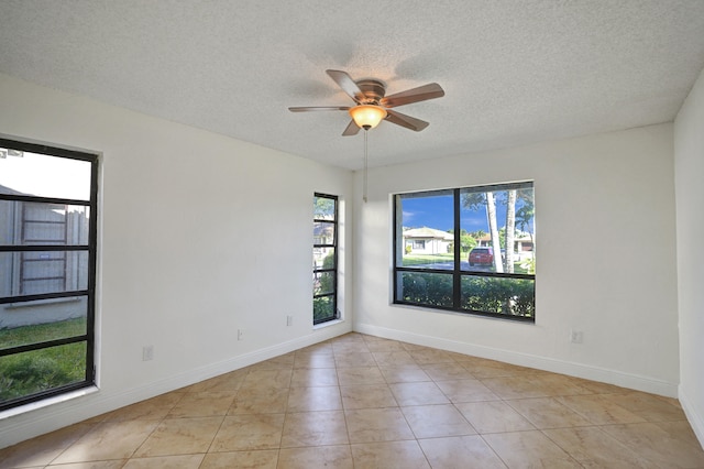 tiled empty room featuring ceiling fan and a textured ceiling