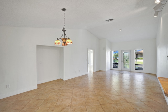 tiled spare room with a chandelier and lofted ceiling