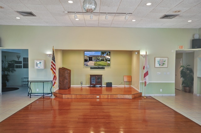 living room with tile patterned flooring, a towering ceiling, and rail lighting