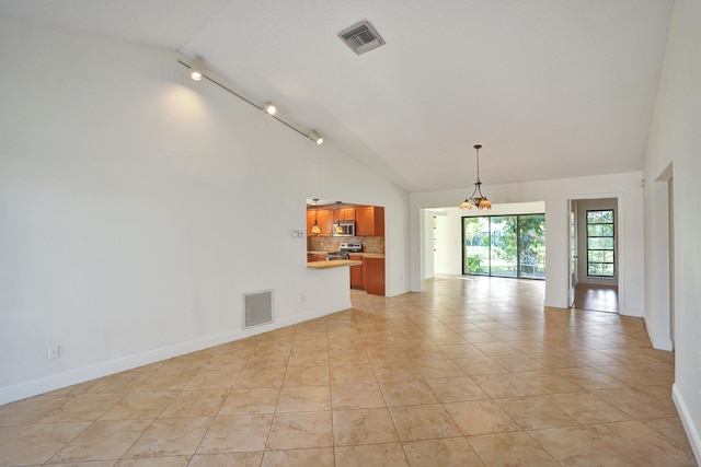 tiled empty room featuring track lighting and high vaulted ceiling