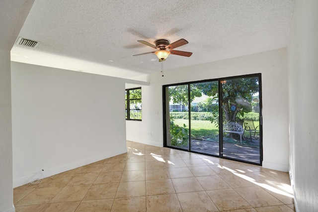 tiled spare room featuring ceiling fan and a textured ceiling