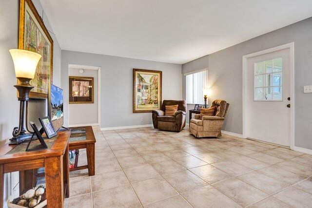 sitting room with light tile patterned flooring and baseboards