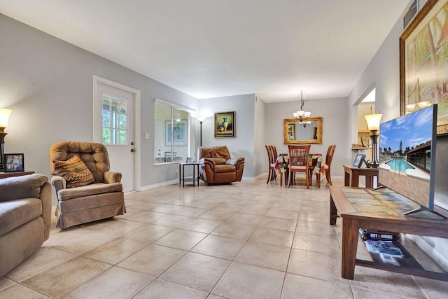 living area with baseboards, light tile patterned flooring, and a notable chandelier