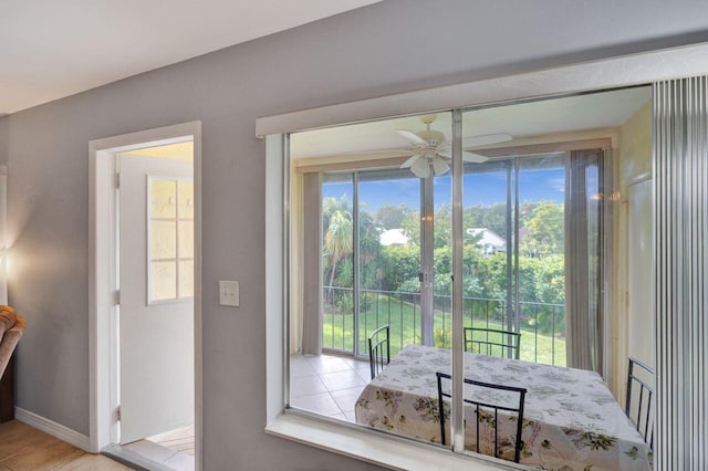 doorway featuring baseboards and a ceiling fan