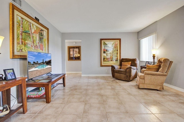 living area featuring light tile patterned flooring, visible vents, and baseboards