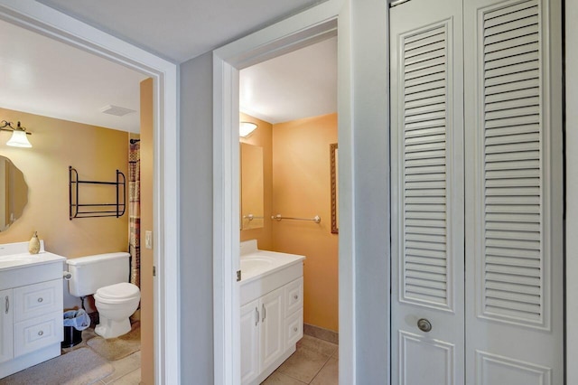 full bath featuring toilet, a closet, vanity, and tile patterned floors