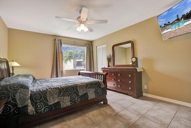 bedroom with ceiling fan, light tile patterned floors, and baseboards