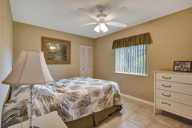 bedroom with a closet, ceiling fan, baseboards, and light tile patterned floors