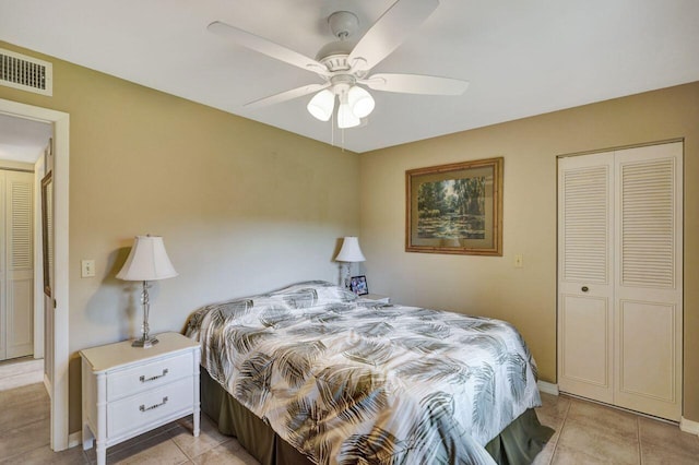 bedroom featuring light tile patterned floors, visible vents, baseboards, ceiling fan, and a closet