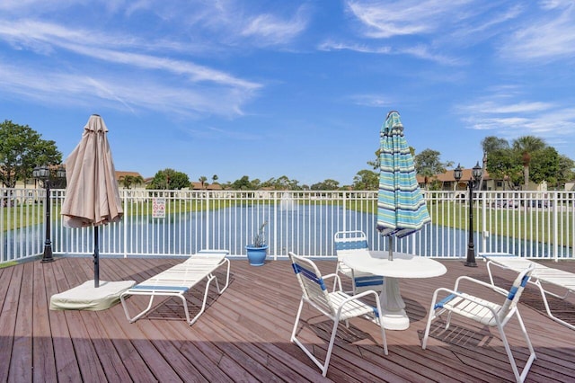 wooden deck with a water view and fence