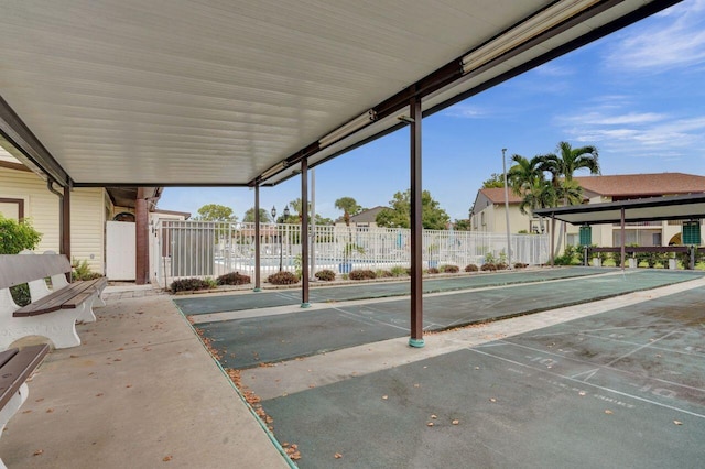 view of patio with shuffleboard and fence