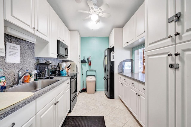 kitchen with light tile patterned floors, decorative backsplash, white cabinetry, a sink, and black appliances