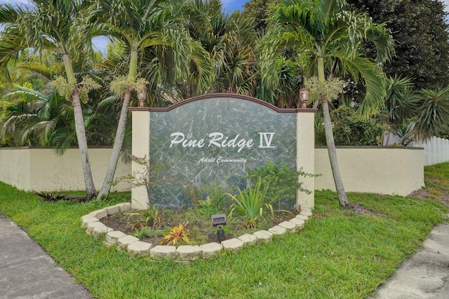 community sign with a lawn and fence