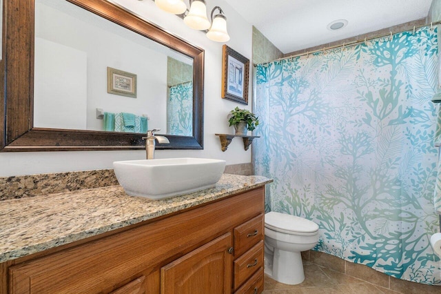 bathroom featuring tile patterned flooring, walk in shower, vanity, and toilet