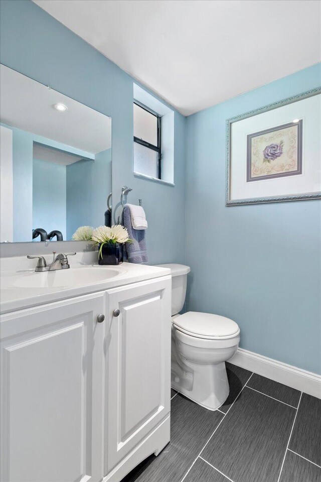 bathroom with vanity, toilet, and tile patterned floors