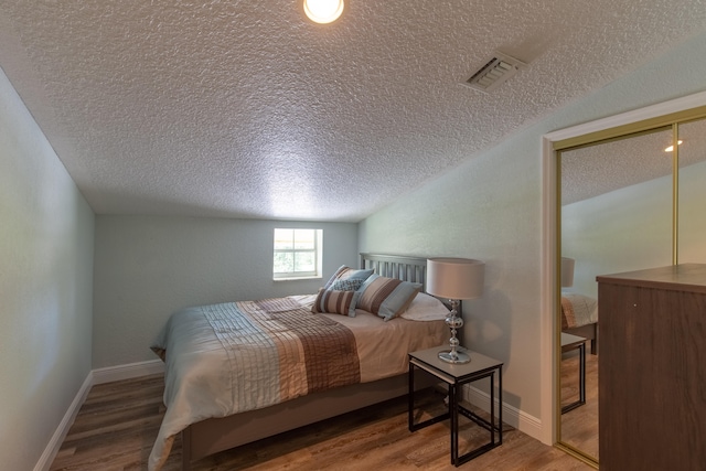 bedroom featuring hardwood / wood-style flooring and a textured ceiling