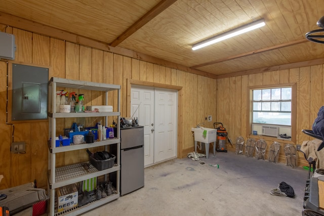 interior space with wooden walls, electric panel, and stainless steel refrigerator