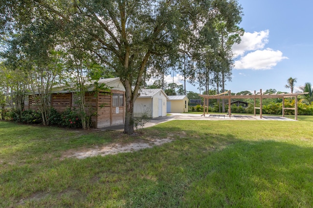 view of yard with a garage and an outbuilding