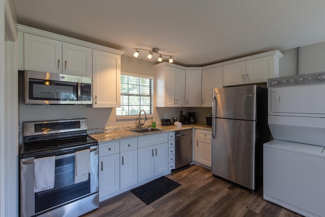 kitchen with dark wood-type flooring, white cabinets, light stone counters, sink, and stainless steel appliances