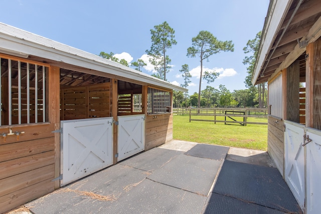 view of horse barn featuring a lawn and an outbuilding