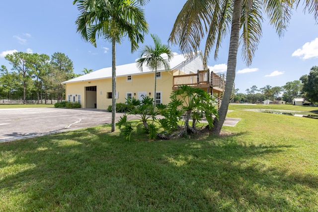 view of front facade with a wooden deck and a front yard