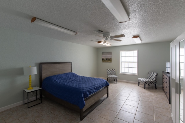 tiled bedroom featuring a textured ceiling and ceiling fan