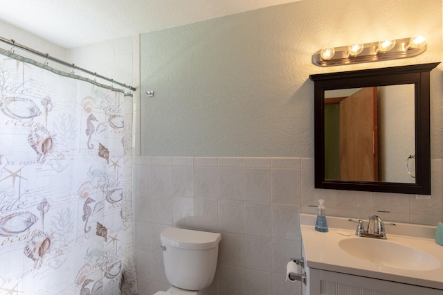 bathroom featuring decorative backsplash, vanity, a textured ceiling, tile walls, and toilet