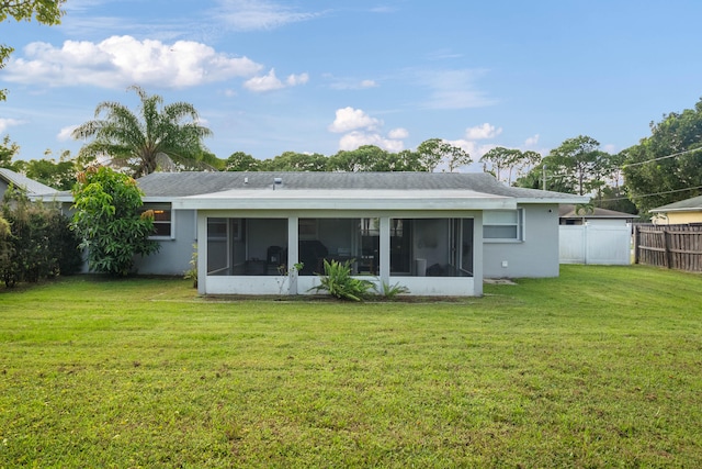 rear view of property featuring a sunroom and a lawn