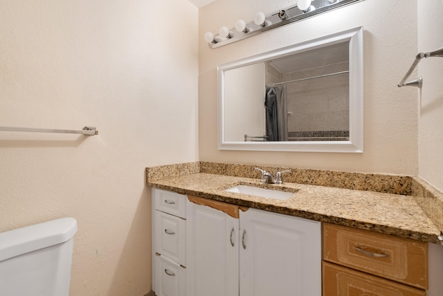 bathroom featuring a shower with curtain, vanity, and toilet