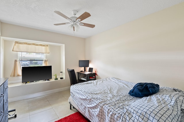 tiled bedroom featuring a textured ceiling and ceiling fan