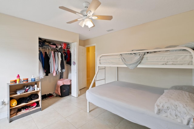 tiled bedroom with ceiling fan and a closet