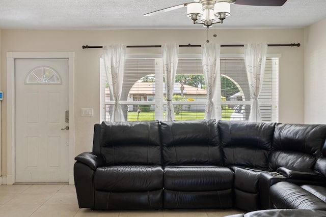 tiled living room featuring ceiling fan and a textured ceiling