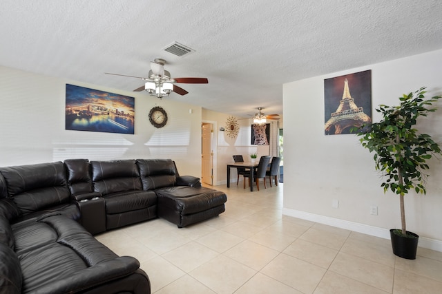 living room featuring a textured ceiling, light tile patterned flooring, and ceiling fan