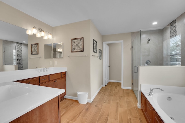 bathroom with hardwood / wood-style flooring, vanity, and shower with separate bathtub