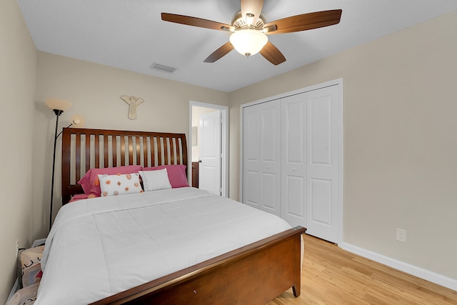 bedroom with ceiling fan, a closet, and light hardwood / wood-style floors