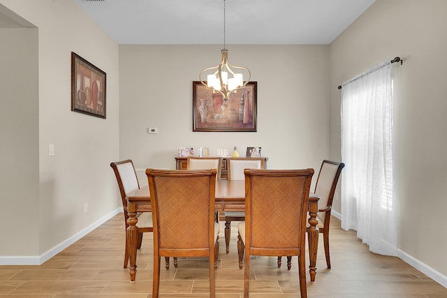 dining room featuring light wood-type flooring and a chandelier