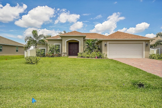 mediterranean / spanish-style house with a garage and a front lawn