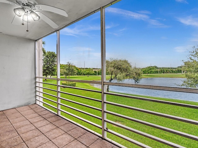 unfurnished sunroom featuring a water view and a ceiling fan