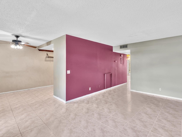 tiled spare room featuring ceiling fan and a textured ceiling