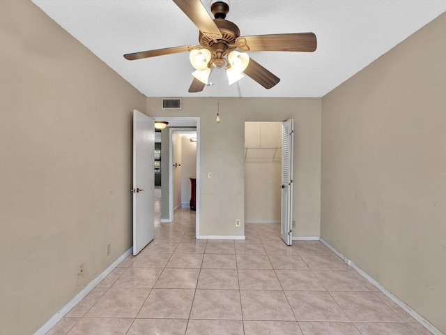 unfurnished bedroom with ceiling fan, a closet, and light tile patterned flooring