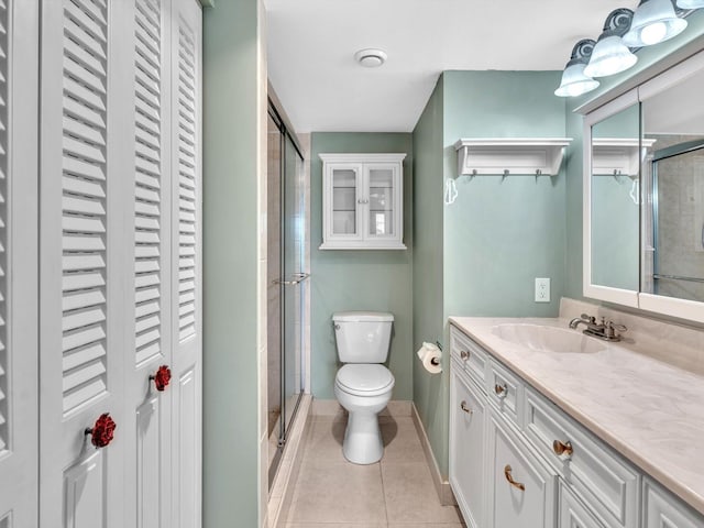 bathroom featuring tile patterned flooring, an enclosed shower, toilet, and vanity