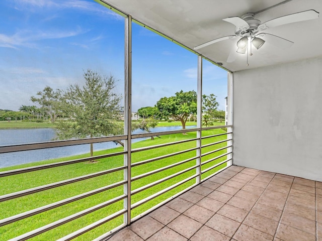 unfurnished sunroom with ceiling fan and a water view