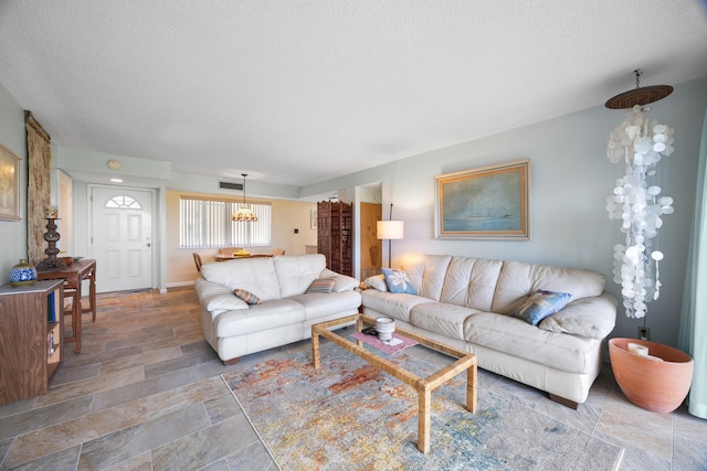 living room featuring a textured ceiling and a chandelier