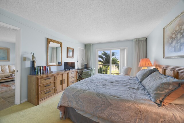 carpeted bedroom with access to outside and a textured ceiling