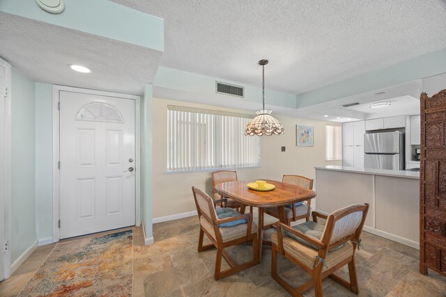 tiled dining room with a textured ceiling