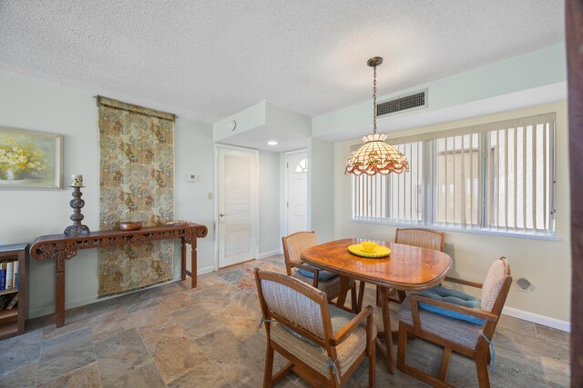 dining area with tile patterned floors and a textured ceiling