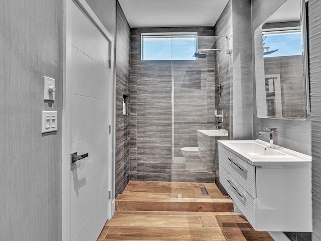 bathroom featuring a walk in shower, tile walls, and vanity